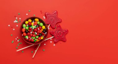 Various candy sweets on red background and copy space for your text. Flat lay