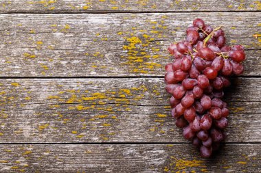 Ahşap masada kırmızı üzüm. Kopyalama alanı olan düz
