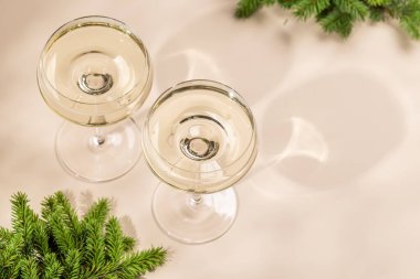 Bej arka planda fotokopi alanı olan iki şampanya bardağı. Noel tebrik kartı şablonu