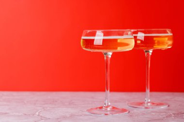 Kırmızı arka planda iki şampanya bardağı.