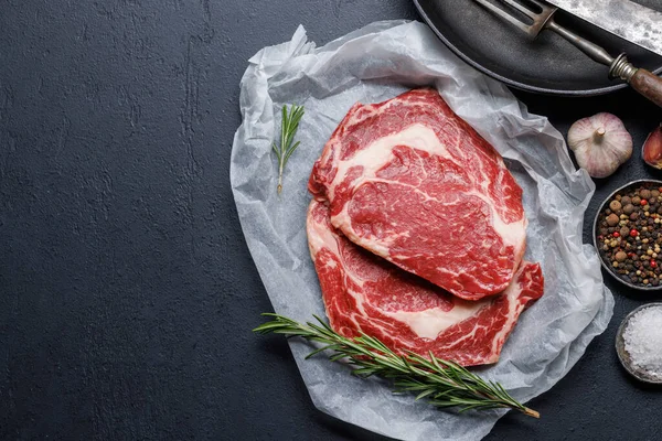 Rauwe Ribeye Steaks Met Hartige Kruiden Vlakke Lay Met Kopieerruimte — Stockfoto