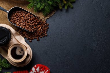 Kahve fincanı, kavrulmuş kahve çekirdekleri ve sıcak bir ortamda köknar ağacı dalları. Fotokopi alanı olan düz bir Noel kartı