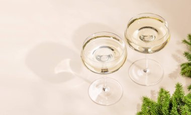 Bej arka planda fotokopi alanı olan iki şampanya bardağı. Noel tebrik kartı şablonu