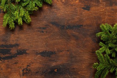 Noel ağacı dalları ahşap üzerinde selamlaşma metni için yer olan bir çerçeve. Düz yatıyordu