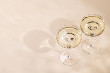 Bej arka planda fotokopi alanı olan iki şampanya bardağı.