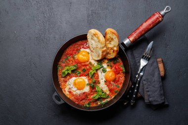 Tavada nefis shakshuka kahvaltısı. Kopyalama alanı olan düz