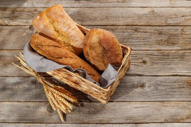 Assorted bread varieties in a charming basket, ready to be enjoyed. With copy space