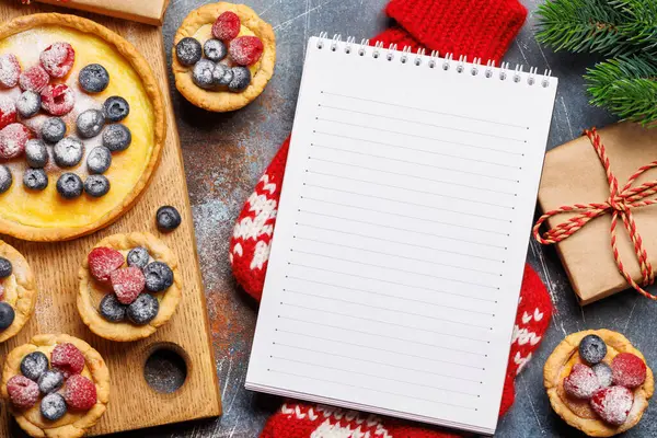 节日快乐 圣诞纸杯蛋糕装饰着浆果 你的食谱或问候语的平铺和记事本放在一起 — 图库照片