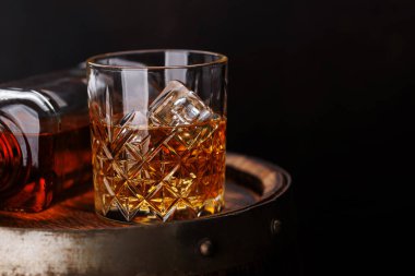 Kırsal bir fıçıda buzlu viski bardağı, klasik bir yudum. Kopyalama alanı ile