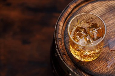 Kırsal bir fıçıda buzlu viski bardağı, klasik bir yudum. Kopyalama alanı ile