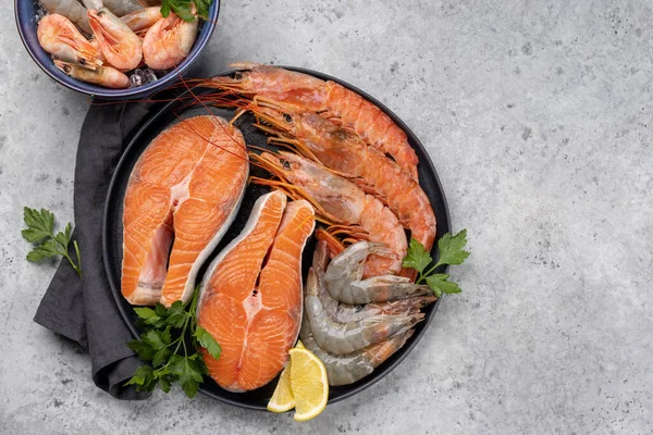 Karides, Langoustine ve alabalık bifteği gibi taze deniz ürünleri manzarası. Kopyalama alanı olan düz