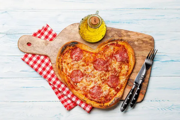 Heart-shaped pizza: Delicious love-themed dish. Flat lay