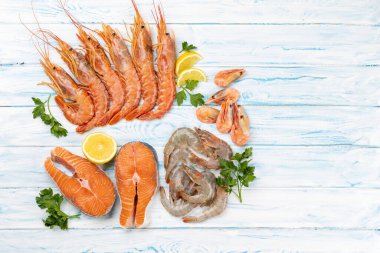 Karides, Langoustine ve alabalık bifteği gibi taze deniz ürünleri manzarası. Kopyalama alanı olan düz