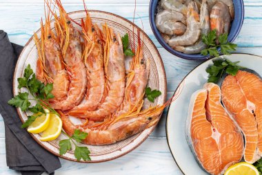 Karides, Langoustine ve alabalık bifteği gibi taze deniz ürünleri manzarası. Düz yatıyordu