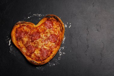 Kalp şeklinde pizza: lezzetli aşk temalı yemek. Kopyalama alanı olan düz