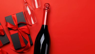 Şampanya ve hediye: kırmızı zemin üzerinde metin alanı olan kutlama ikilisi. Sevgililer Günü tebrik kartı.