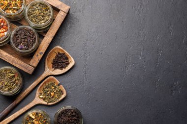 Çay saatleri: çeşitli kuru çay yaprakları ve çaydanlık. Kopyalama alanı olan düz