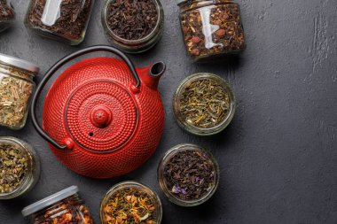 Çay saatleri: çeşitli kuru çay yaprakları ve çaydanlık. Kopyalama alanı olan düz