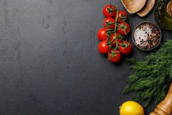 Cooking scene: Cherry tomatoes, herbs and spices on table. Flat lay with copy space