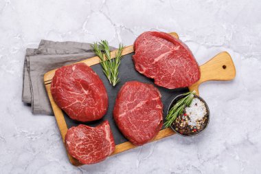 Kesme tahtasında çiğ biftek, taze ve pişmemiş. Düz yatıyordu