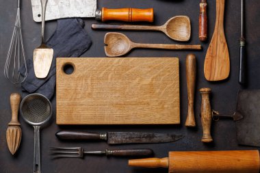 Mutfak gereksinimleri: çeşitli mutfak aletleri ve taş masanın üzerindeki ahşap tahta tahta. Düz yatıyordu