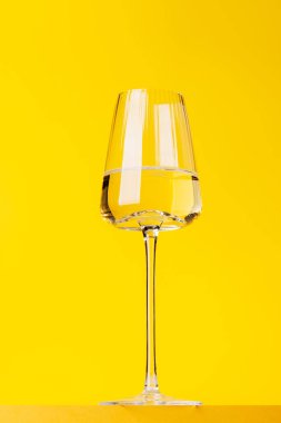 Şampanya zarafeti, parlak sarı arka planda köpüklü şarap kadehi. Kopyalama alanı ile