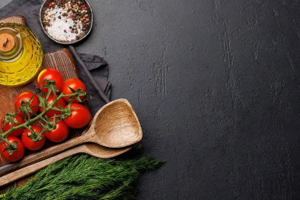 Cooking scene: Cherry tomatoes, herbs and spices on table. Flat lay with copy space