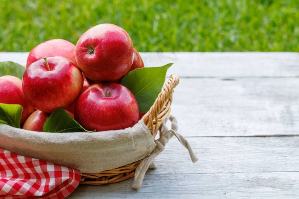 stock image Basket with fresh red apples on the garden table with copy space