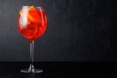 Aperol spritz kokteyli, portakal dilimi ve koyu arkaplanda buzlu fotokopi alanı.