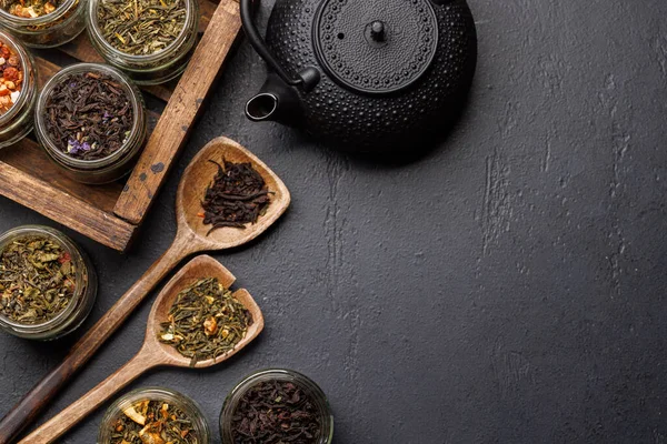 Çay saatleri: çeşitli kuru çay yaprakları ve çaydanlık. Kopyalama alanı olan düz