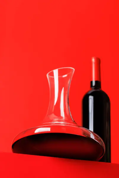 Rode Wijn Elegantie Decanter Wijnfles Tegen Een Levendige Rode Achtergrond — Stockfoto