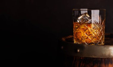 Kırsal bir fıçıda buzlu viski bardağı, klasik bir yudum. Kopyalama alanı ile