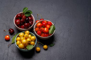 Canlı ve renkli bir kiraz, tatlı sularla dolup taşıyor. Güneşli bahçe masasında. Kopyalama alanı ile