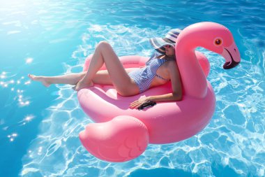 Bikini 'deki Kadın Havuzda Şişirilebilir Flamingo Üzerine