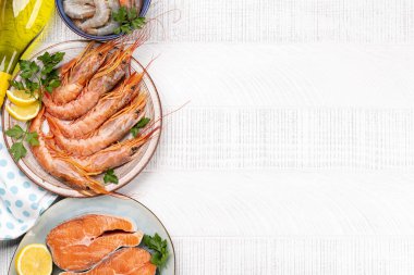 Beyaz şarap eşliğinde karides, langoustine ve alabalık bifteği gibi taze deniz ürünlerinin üst görüntüsü. Kopyalama alanı olan düz