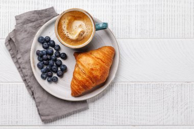 Cappuccino kahve ve ahşap masada taze kruvasan. Kopyalama alanı olan düz