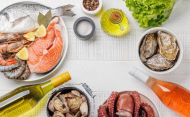 Deniz ürünleri tabağı: karides, somon, istiridye ve şarap şişeleri. Kopyalama alanı ile