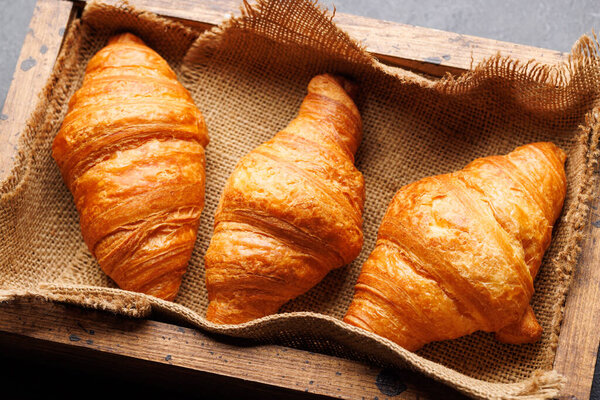Fresh croissants in wooden box