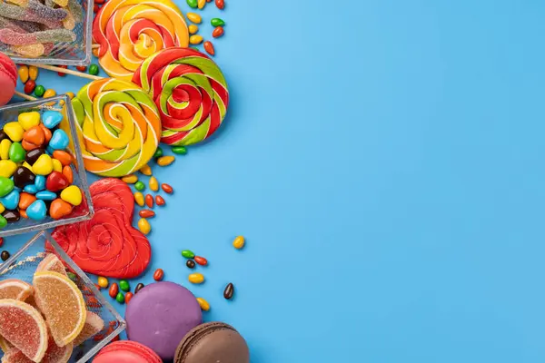 Varios Caramelos Coloridos Piruletas Macarrones Dulces Planos Sobre Fondo Azul —  Fotos de Stock