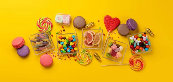 Various Colorful Candies Lollipops Macaroons Flat Lay Sweets Yellow Background Stock Image