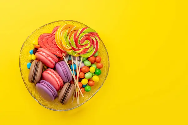 Various Colorful Candies Lollipops Macaroons Flat Lay Yellow Background Copy Royalty Free Stock Images
