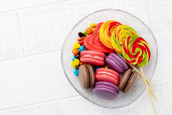 Divers Bonbons Colorés Sucettes Macarons Pose Plate Sur Fond Bois Image En Vente