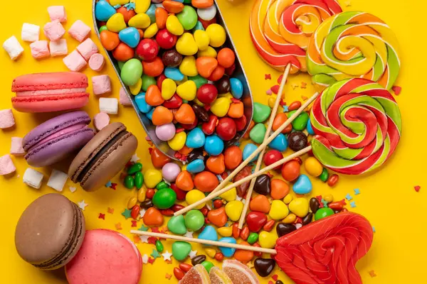 Various Colorful Candies Lollipops Macaroons Flat Lay Yellow Background Stock Picture