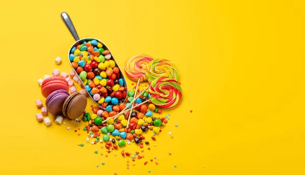 Diverse Kleurrijke Snoepjes Lolly Macarons Gele Achtergrond Met Kopieerruimte Rechtenvrije Stockafbeeldingen