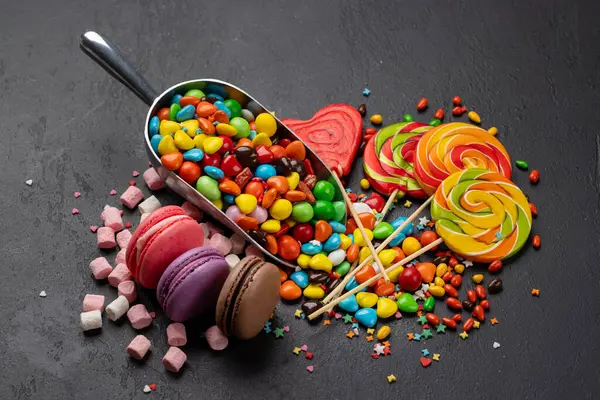 Various Colorful Candies Lollipops Macaroons Sweets Stone Background Stock Photo