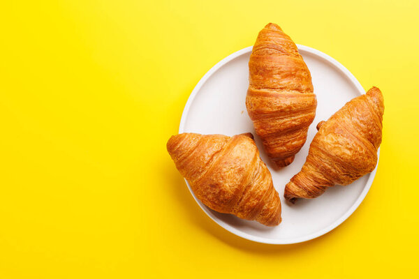 Fresh croissants on plate. Flat lay with copy space
