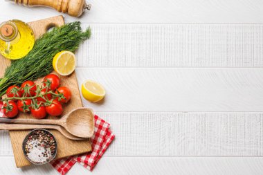 Yemek sahnesi: kiraz domatesleri, otlar ve baharatlar masada. Kopyalama alanı olan düz