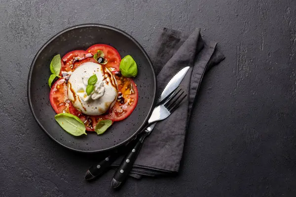 Antipasto with burrata cheese, tomatoes and basil. Italian cuisine. Flat lay with copy space