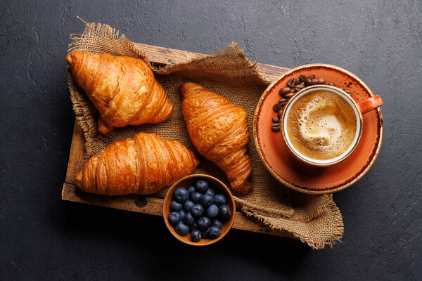 Cappuccino coffee and fresh croissants on stone table. Flat lay