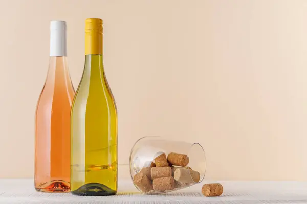 Rosen Und Weißweinflaschen Auf Tisch Mit Kopierplatz lizenzfreie Stockfotos
